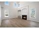 Bright living room featuring vaulted ceilings, a fireplace, large windows, and wood floors at 10950 Glenhurst Pass, Duluth, GA 30097