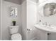 Cozy powder room with white beadboard walls, pedestal sink, and decorative mirror at 55 Little Barley Ln, Grayson, GA 30017