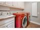 This laundry room features new red washer and dryer and a utility sink at 55 Little Barley Ln, Grayson, GA 30017