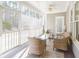Relaxing sunroom with wicker furniture, ceiling fan, and views of the wooded backyard at 55 Little Barley Ln, Grayson, GA 30017