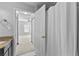 This bright bathroom offers a shower with white curtain and an open door looking into the bedroom at 1075 Peachtree Walk # A-307, Atlanta, GA 30309