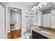 Bright bathroom features granite counters, decorative lighting, and an adjacent door with wood floors at 1075 Peachtree Walk # A-307, Atlanta, GA 30309