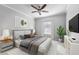 This staged bedroom includes a ceiling fan, neutral walls, and a window providing natural light at 1075 Peachtree Walk # A-307, Atlanta, GA 30309