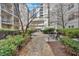 Serene courtyard with stone pathway, lush landscaping, and wrought iron tables for relaxation at 1075 Peachtree Walk # A-307, Atlanta, GA 30309