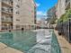 Community swimming pool with a safety cover, surrounded by a metal fence for added security at 1075 Peachtree Walk # A-307, Atlanta, GA 30309