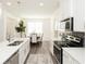 Well-lit kitchen featuring stainless steel appliances, white cabinetry, and an open layout that connects to the dining area at 2456 Honey Way, Conyers, GA 30013