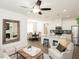 Open concept living room with eat-in kitchen, a large mirror above the fireplace, and ceiling fan at 2456 Honey Way, Conyers, GA 30013