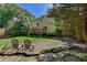 Fenced backyard showcasing a screened in patio, lush lawn, mature trees and stone terracing at 4580 Windsor Park Place, Atlanta, GA 30342