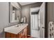 Neutral bathroom features a wood vanity with a white countertop, a mirror, and a view of the shower/toilet room at 4580 Windsor Park Place, Atlanta, GA 30342