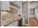 Close up of a butler's pantry featuring granite countertops, wine storage, and custom cabinetry at 4580 Windsor Park Place, Atlanta, GA 30342