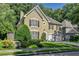 Traditional home with well-manicured landscaping, dark shutters, an attached garage, and a paved driveway at 4580 Windsor Park Place, Atlanta, GA 30342