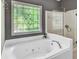 Bathroom featuring a modern soaking tub, glass enclosed shower and decorative window at 4580 Windsor Park Place, Atlanta, GA 30342