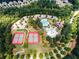 Aerial shot of community amenities including a pool, tennis courts, clubhouse, and parking, surrounded by lush trees at 923 Buckhorn Bnd, Locust Grove, GA 30248