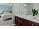 Stylish bathroom vanity with modern faucet, mirror, lighting and a glimpse into the well-lit bedroom at 923 Buckhorn Bnd, Locust Grove, GA 30248