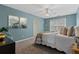 Bright bedroom featuring blue walls, ceiling fan, natural light, and decorative wall art at 923 Buckhorn Bnd, Locust Grove, GA 30248