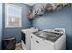 Laundry room with newer white washer and dryer and storage shelves at 923 Buckhorn Bnd, Locust Grove, GA 30248