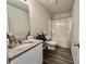 Bright bathroom with wood-look flooring, granite vanity and shower-tub at 720 Dove Tree Ln, Social Circle, GA 30025
