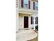 Front door is a dark wood with a covered stoop and siding at 720 Dove Tree Ln, Social Circle, GA 30025