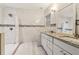 Bright bathroom featuring double sinks with granite countertops, tiled walls, and a shower with glass doors at 1268 Wylie Se St, Atlanta, GA 30317