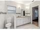 Bathroom with double sinks, tiled floors and walls, and toilet adjacent to doorway at 1268 Wylie Se St, Atlanta, GA 30317