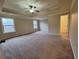 Spacious bedroom with neutral carpet and tray ceiling with fan and recessed lighting at 1831 Nours Landing Way, Duluth, GA 30097