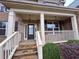 Inviting front porch with stone steps, decorative pillars, and detailed railing at 1831 Nours Landing Way, Duluth, GA 30097