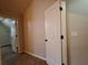 Hallway with tile flooring leading to a closet with wire shelving and a door at 1831 Nours Landing Way, Duluth, GA 30097