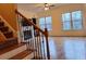 Sunlit living room with fireplace, hardwood floors, large windows, and staircase at 1831 Nours Landing Way, Duluth, GA 30097