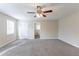 Bedroom with plush carpeting, ceiling fan, and a view into an adjacent room at 6297 Temple St, Lithia Springs, GA 30122