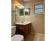 Half bathroom with cherry vanity, marble countertop, and new lighting at 6900 Roswell Rd # 7N, Atlanta, GA 30328