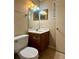 Half bathroom with cherry vanity, marble countertop, and new lighting at 6900 Roswell Rd # 7N, Atlanta, GA 30328