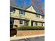 Beautiful townhome exterior featuring a brick base, upper level windows, and a manicured green hedge at 6900 Roswell Rd # 7N, Atlanta, GA 30328