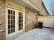 A small patio featuring a wooden fence, AC Unit and the side of a brick building with double doors at 6900 Roswell Rd # 7N, Atlanta, GA 30328