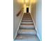 Carpeted staircase with wooden handrail leading to the upper level at 6900 Roswell Rd # 7N, Atlanta, GA 30328