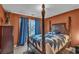 Bedroom with a four-poster bed, blue curtains, and warm orange walls at 8034 Bradshaw Ct, Douglasville, GA 30134