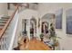 Inviting foyer with hardwood floors, staircase, and decorative guitar leading to arched entryways at 8034 Bradshaw Ct, Douglasville, GA 30134