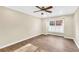 A bright, unfurnished bedroom with hardwood floors, a ceiling fan and a large window with bright light at 1482 N Crossing Ne Cir, Atlanta, GA 30329