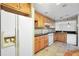 Bright kitchen with white appliances and wooden cabinetry, featuring a refrigerator and a gas range at 1482 N Crossing Ne Cir, Atlanta, GA 30329