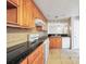 An airy kitchen featuring wooden cabinetry, black countertops, and white appliances including a gas range at 1482 N Crossing Ne Cir, Atlanta, GA 30329