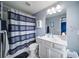 Cozy bathroom featuring stylish shower curtain, vanity with mirror, and cabinet at 322 Kells Ct, Woodstock, GA 30188