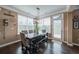 Charming dining area featuring dark hardwood floors, a rustic table, and ample natural light from surrounding windows at 322 Kells Ct, Woodstock, GA 30188