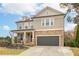 Charming two-story home with a stone facade, covered front porch, and a well-manicured lawn with professional landscaping at 322 Kells Ct, Woodstock, GA 30188