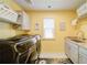 Bright laundry room features modern washer/dryer, ample counter space, cabinets, and cheerful yellow walls at 322 Kells Ct, Woodstock, GA 30188