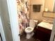 Functional bathroom with a floral shower curtain, a toilet, and a white porcelain sink at 6473 Bedford Ln, Lithonia, GA 30058