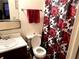 Cozy bathroom featuring a floral shower curtain, a toilet, and a sink with cabinet at 6473 Bedford Ln, Lithonia, GA 30058