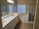 Well-lit bathroom featuring double sinks, a soaking tub, and a glass-enclosed shower at 2110 Retreat Haven Ln, Dacula, GA 30019