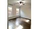 Bright bedroom with hardwood floors, ceiling fan, and natural light from two large windows at 3879 Glenview Club Ln, Duluth, GA 30097