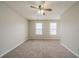 Comfortable bedroom with neutral carpeting, ceiling fan, and large windows for ample sunlight at 821 Stonebridge Park Cir, Lithonia, GA 30058