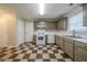 Well-lit kitchen featuring checkerboard floors, ample counter space, and access to an exterior door at 821 Stonebridge Park Cir, Lithonia, GA 30058