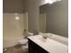 A bathroom with a shower-tub combo, toilet, vanity and a large mirror at 5223 Catrina Way, Buford, GA 30519